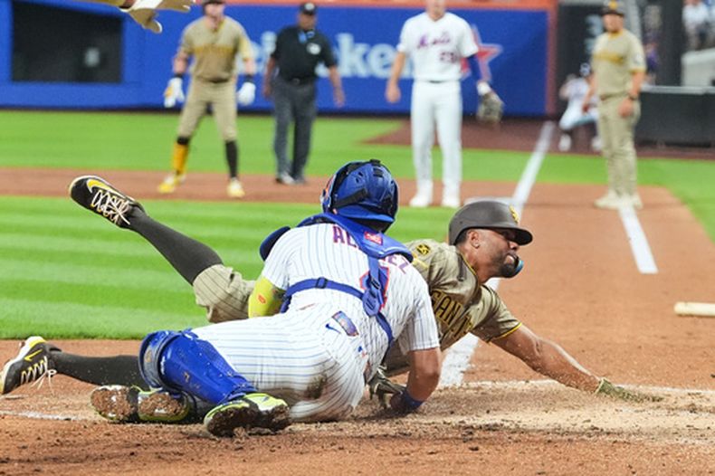 Francisco Alvarez (4), receptor de los Mets de Nueva York, pone fuera en el plato a Xander Bogaerts, de los Padres de San Diego, durante la segunda entrada del juego de béisbol de Grandes Ligas, el lunes 17 de agosto de 2026, en Nueva York. (AP Foto/Frank Franklin II)