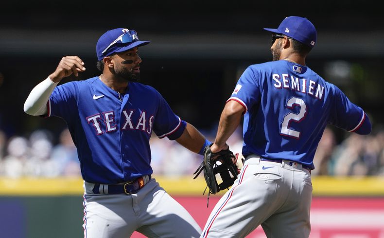 Ezequiel Durán, de los Rangers de Texas, celebra con su compañero de equipo Marcus Semien (2) después de una victoria por 4-3 en contra de los Marineros de Seattle, en el juego de béisbol del miércoles 10 de mayo de 2023, en Seattle. (AP Foto/Lindsey Wasson)