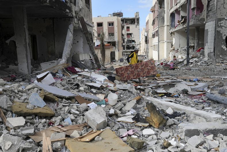 Un hombre palestino recoge sus pertenencias en Ciudad Gaza el 28 de noviembre de 2023. . (Foto AP/Adel Hana)