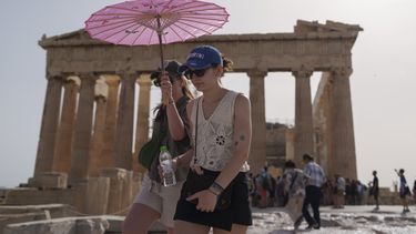 Turistas caminan por la Acrópolis, en Atenas, Grecia, bajo el fuerte calor, el 12 de junio de 2024. (AP Foto/Petros Giannakouris, Archivo)