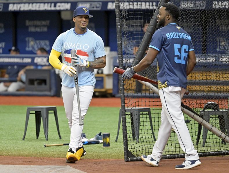 Wander Franco, izquierda, de los Rays de Tampa Bay, y Vidal Brujan, quien porta un jersey de Arozarena, cambian posiciones durante una sesión de práctica de bateo antes del partido en contra de los Reales de Kansas City, el sábado 24 de junio de 2023, en San Petersburgo, Florida. Franco regresa a la alineación después de haber sido mandado a la banda por dos partidos. (AP Foto/Steve Nesius)