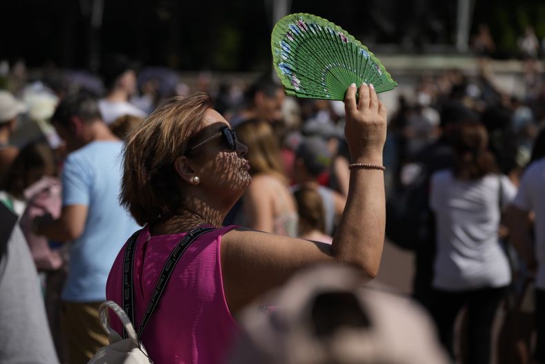 Una persona se abanica contra el calor frente al Palacio de Buckingham en Londres el 18 de julio de 2022. (Foto AP /Matt Dunham)