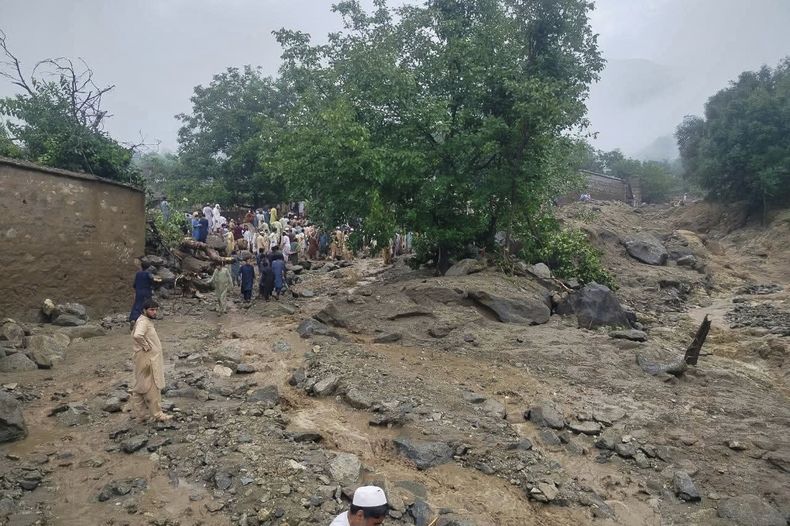 En esta imagen, distribuida por el servicio de emergencias 1122, rescatistas y residentes se congregan en el lugar donde los aguaceros causaron inundaciones repentinas, en Salarzai, Pakistán, el 15 de agosto de 2025. (Servicio de Emergencias 1122 vía AP)