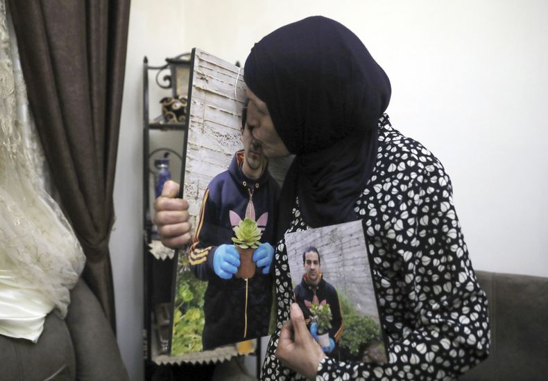Rana besa una foto de su hijo, Eyad Hallaq, en su casa en Wadi Joz, un barrio palestino en el este de Jerusalén el 3 de junio de 2020. Hallaq era autista y fue baleado por agentes israelíes hace tres años, en un caso que el tribunal determinó como homicidio imprudente, el 6 de julio de 2023. (Foto AP/Mahmoud Illean, archivo)