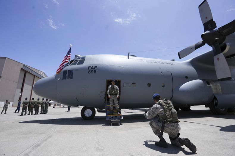 Miembros de la Fuerza Aérea Ecuatoriana posan para fotos con el avión Hércules donado por Estados Unidos a Ecuador para misiones militares, en el aeropuerto de Cotopaxi tras el acto de entrega, en Latacunga, Ecuador, el lunes 25 de marzo de 2024. (AP Foto/Dolores Ochoa)