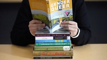 Amanda Darrow, directora de programas educativos y familiares del Utah Pride Center, posa con libros que han sido criticados por padres, incluyendo Gender Queer por Meir Kobabe, el 16 de diciembre de 2021, en Salt Lake City. (AP foto/Rick Bowmer)