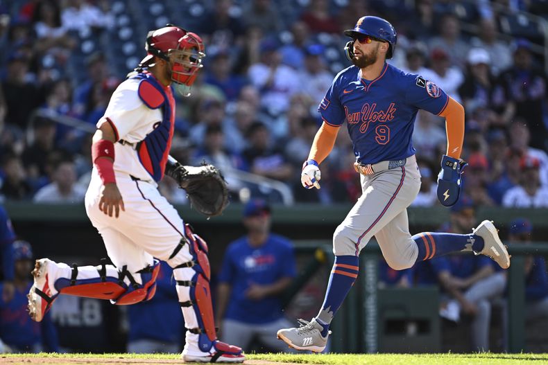 Brandon Nimmo de los Mets de Nueva York anota con un elevado de sacrificio de Jeff McNeil frente al pitcher de los Nacionales de Washington Trevor Williams en el encuentro del lunes 28 de abril del 2025. (AP Foto/Terrance Williams)