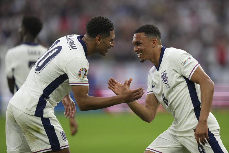Los ingleses Jude Bellingham y Trent Alexander-Arnold celebran tras el primer gol de su selección en el encuentro ante Serbia en el Grupo C de la Euro 2024 el domingo 16 de junio del 2024. (AP Foto/Martin Meissner)