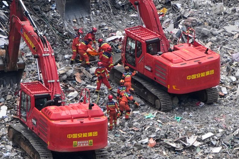 Rescatistas auxilian a una víctima atrapada entre escombros, en el lugar donde ocurrió un deslave en el condado Pengshui, en el suroeste de la región de Chongqing, China, el domingo 19 de julio de 2026. (AP Foto/Andy Wong)