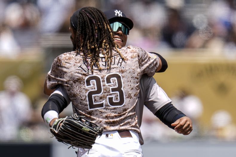 El jardinero Juan Soto, derecha, de los Yankees de Nueva York, abraza a Fernando Tatis Jr. (23), de los Padres de San Diego, durante la segunda entrada del juego de béisbol, el domingo 26 de mayo de 2024, en San Diego. (AP Foto/Gregory Bull)
