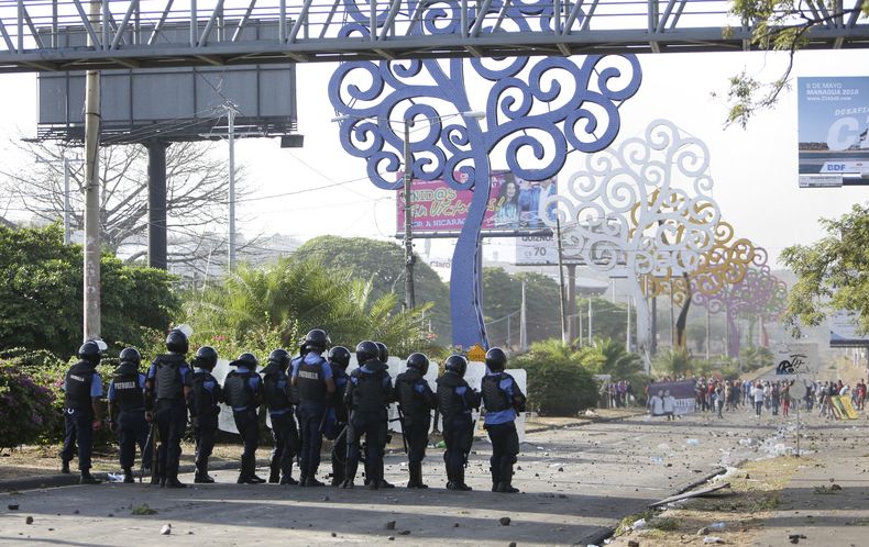 ARCHIVO - Policías y manifestantes se enfrentan en Managua, Nicaragua, 20 de abril de 2018. Una investigación divulgada el 28 de abril de 2023 por el Colectivo de Derechos Humanos Nicaragua Nunca Más reportó que al menos 158 personas detenidas en Nicaragua desde las protestas de 2018 sufrió torturas y la mayoría fueron víctimas de violencia sexual por parte de funcionarios penitenciarios y altos mandos policiales. (AP Foto/Alfredo Zuniga, Archivo)