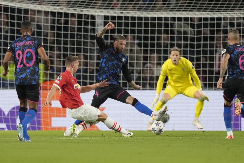 Luuk de Jong del PSV patea el balón frente a Sergio Ramos del Sevilla en el encuentro del Grupo B de la Liga de Campeones el martes 3 de octubre del 2023. (AP Foto/Peter Dejong)