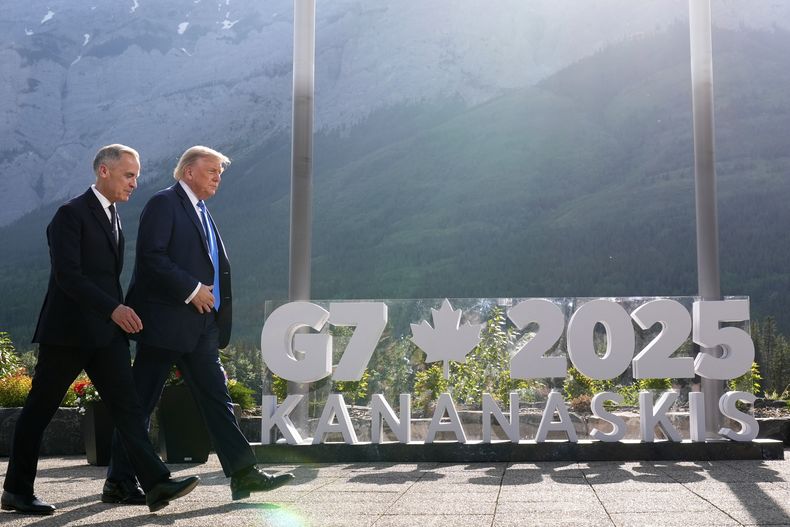 El primer ministro canadiense Mark Carney camina junto al presidente estadounidense Donald Trump tras una foto de grupo en la cumbre del G7, el lunes 16 de junio de 2025, en Kananaskis, Canadá. (AP Foto/Mark Schiefelbein)