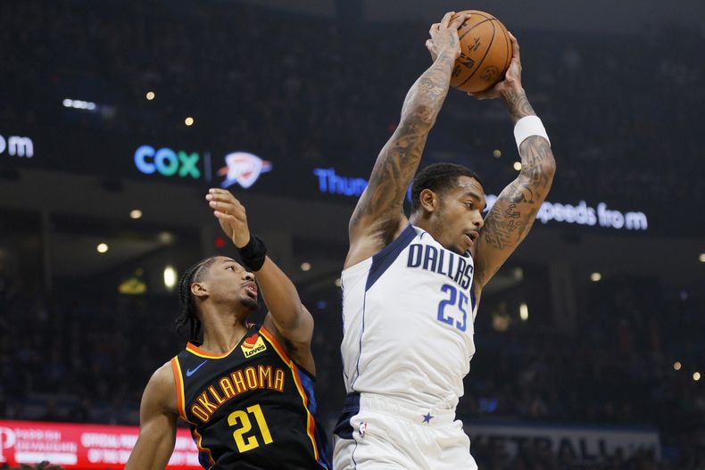 El alero de los Mavericks de Dallas, P.J. Washington (25), captura un rebote junto al escolta del Thunder de Oklahoma City, Aaron Wiggins (21), durante la primera mitad de un partido de baloncesto de la NBA, el domingo 17 de noviembre de 2024, en Oklahoma City. (AP Foto/Nate Billings)