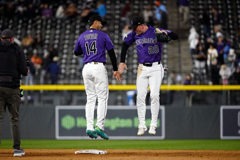 El campocorto de los Rockies de Colorado Ezequiel Tovar y el jardinero derecho Troy Johnston celebran tras vencer a los Astros de Houston el lunes 6 de abril del 2026. (AP Foto/Geneva Heffernan)