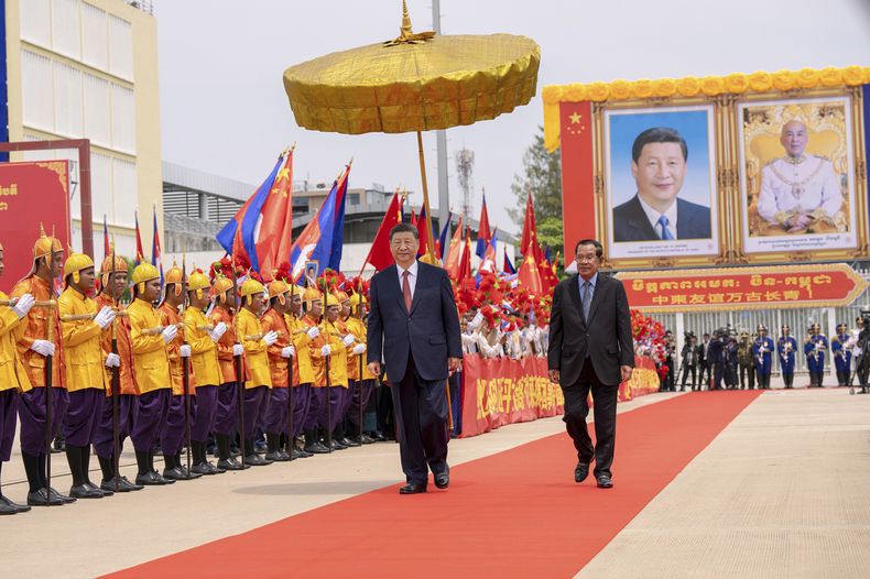 En esta imagen, distribuida por la agencia noticiosa Agence Kampuchea Press (AKP), el presidente de China, Xi Jinping, pasa revista a una guardia de honor en el Palacio Real acompañado por el presidente del Senado de Camboya, Hun Sen (derecha), durante la ceremonia de despedida en el aeropuerto internacional de Nom Pen, Camboya, el 18 de abril de 2025. (AKP vía AP)