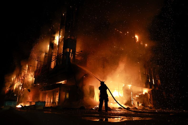 Un trabajador de rescate combate un incendio en el centro de operaciones financieras Intrade tras un ataque de dron ruso en Zaporiyia, Ucrania, el lunes 21 de septiembre de 2026. (AP Foto/Kateryna Klochko)