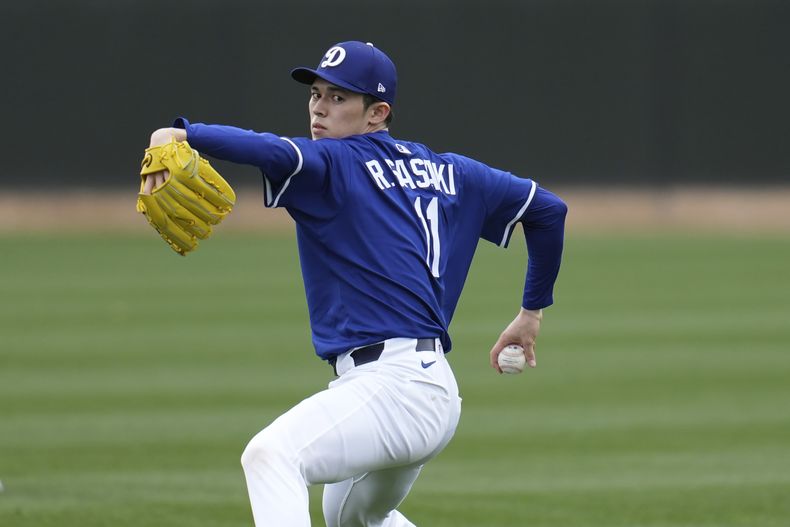 Roki Sasaki, lanzador japonés de los Dodgers de Los Ángeles, calienta el brazo en las instalaciones de los campos de primavera del equipo, el miércoles 12 de febrero de 2025, en Phoenix. (AP Foto/Ross D. Franklin)