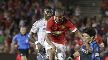 americateve | El jugador de Manchester United Ashley Young, centro, trata de eludir a Brian Rove del LA Galaxy durante un amistoso en el Rose Bowl de Pasadena, California, el 23 de julio del 2014. Manchester United ga&oacute; 7-0 y Young anot&oacute; dos de los goles.