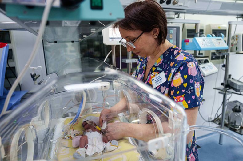 La enfermera Victoria Bohdanova cambia el pañal de un bebé prematuro dentro de una incubadora con temperatura controlada en el centro perinatal regional de Zaporiyia, Ucrania, el miércoles 6 de mayo de 2026. (Foto AP/Evgeniy Maloletka)