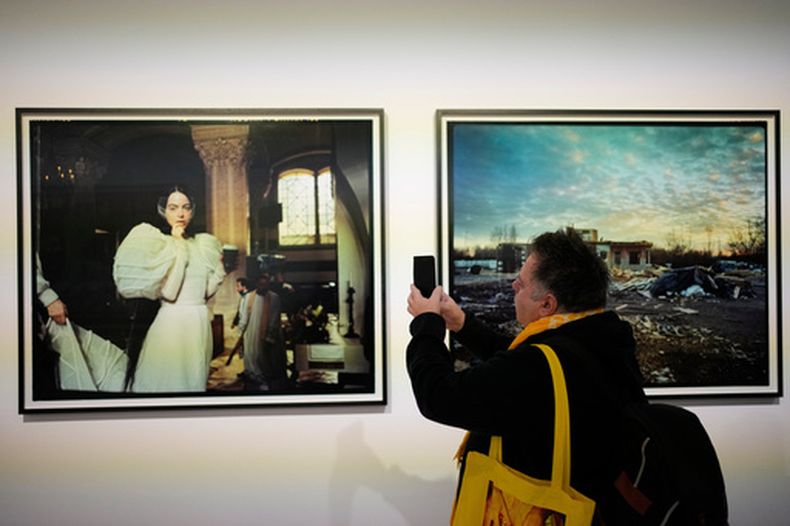 Un visitante toma una fotografía de un retrato de la actriz Emma Stone en una exposición de imágenes del director nominado al Oscar Yorgos Lanthimos en Onassis Stegi en Atenas, Grecia, el viernes 6 de marzo de 2026. (Foto AP/Thanassis Stavrakis)