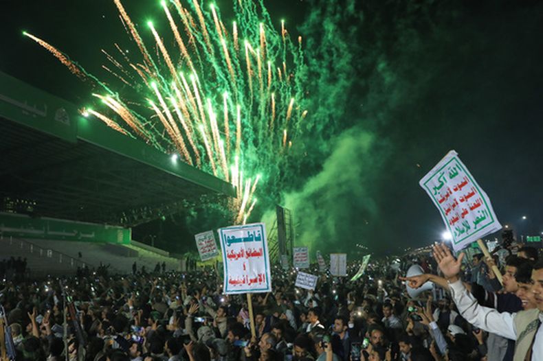 Fuegos artificiales iluminan el cielo mientras simpatizantes de los hutíes marchan contra una coalición encabezada por Arabia Saudí, el lunes 20 de julio de 2026, en Saná, Yemen. Las pancartas en árabe dicen Dios es grande, muerte a Estados Unidos, muerte a Israel, maldición para los judíos y victoria al islam, así como boicot a los productos estadounidenses e israelíes. (AP Foto/Osamah Abdulrahman)