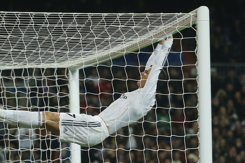 El portugu&eacute;s Cristiano Ronaldo cuelga del travesa&ntilde;o durante un partido de la Copa del Rey, entre el Real Madrid y el Osasuna, el jueves 9 de enero de 2014 (AP Foto/Andres Kudacki)