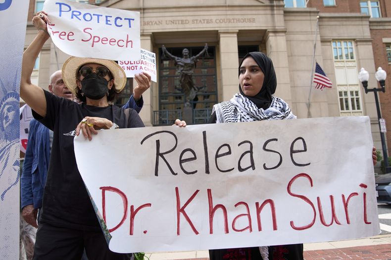 Mapheze Saleh (der), esposa del académico de la Universidad de Georgetown Badar Khan Suri, sujeta un cartel pidiendo la libertad de su esposo en Alexandria, Virginia, el 1 de mayo del 2025. (AP foto/Jacquelyn Martin)
