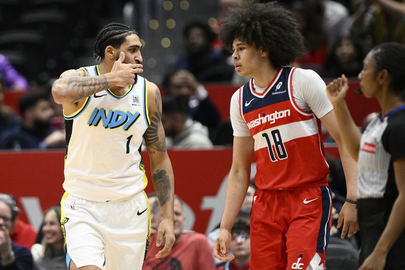 Obi Toppin, alero de los Pacers de Indiana, festeja un triple junto a Kyshawn George, de los Wizards de Washington, el miércoles 12 de febrero de 2025 (AP Foto/Nick Wass)