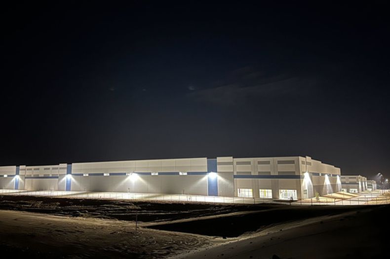 Tres enormes almacenes iluminan la noche en Socorro, Texas, el jueves 12 de febrero de 2026, en medio de la preocupación por la compra de la propiedad por parte de las autoridades federales en relación con la expansión de 45.000 millones de dólares de los centros de detención de inmigrantes del Servicio de Inmigración y Control de Aduanas de Estados Unidos (ICE). (Foto AP/Morgan Lee)