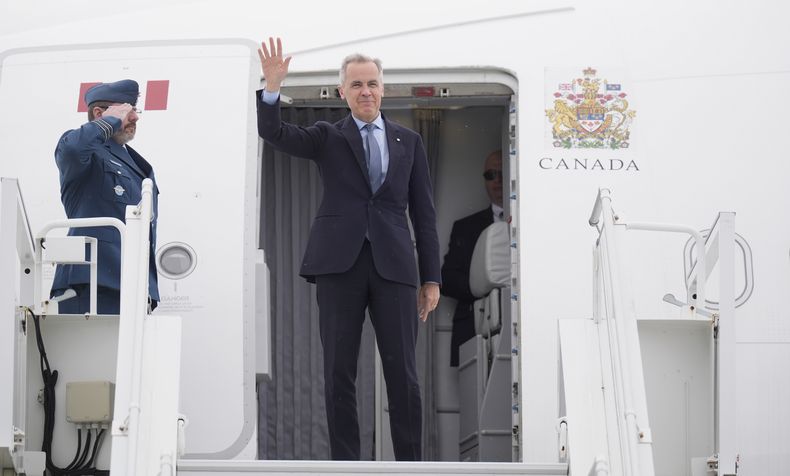 El primer ministro de Canadá, Mark Carney, sube a un avión del gobierno en Ottawa, Ontario, el lunes 5 de mayo de 2025, antes de viajar a Washington para una reunión con el presidente de Estados Unidos, Donald Trump. (Adrian Wyld/The Canadian Press via AP)