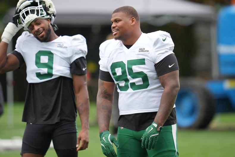 Quinnen Williams (95), tackle defensivo de los Jets de Nueva York, ríe con el ala defensiva Will McDonald IV en una práctica realizada el miércoles 8 de octubre de 2025 (AP Foto/Kin Cheung)