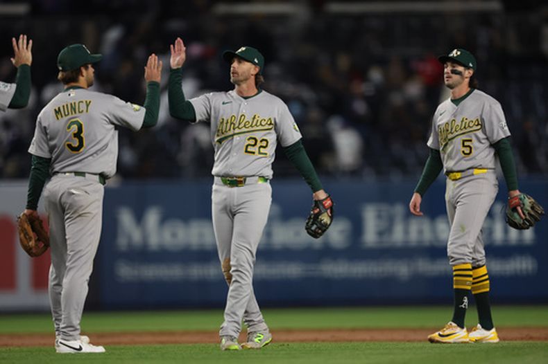 Max Muncy (3) y Jeff McNeil (22), de los Atléticos de Oakland, festejan la victoria sobre los Yankees de Nueva York, el miércoles 8 de abril de 2026 (AP Foto/Heather Khalifa)