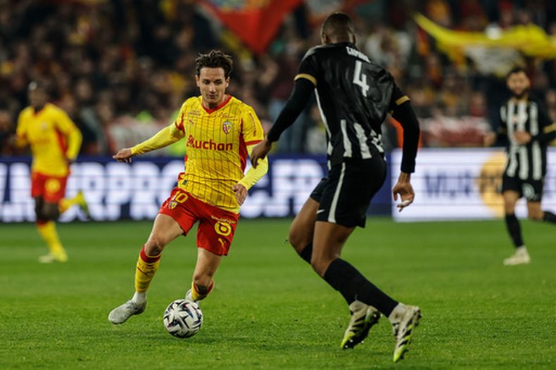 Florian ThauviN de Lens avanza con el balón en el partido contra Angers en la liga francesa, el viernes 20 de marzo de 2026. (AP Foto/Jean-Francois Badias)