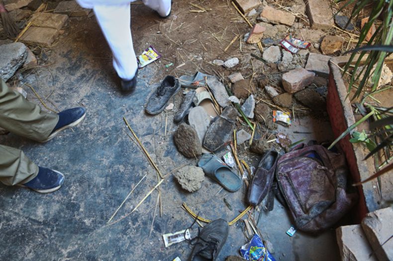 Un rescatista, junto a los zapatos y mochila de una víctima del derrumbe del tejado de una escuela privada, en Peshawar, Pakistán, el 15 de octubre de 2026. (AP Foto/Muhammad Zubair)