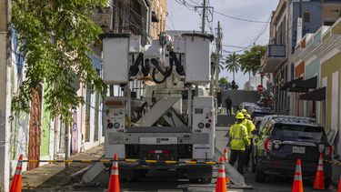 Trabajadores de electricidad realizan reparaciones en la comunidad de Puerta de Tierra tras el paso de la tormenta tropical Ernesto en San Juan, Puerto Rico, el jueves 15 de agosto de 2024. (AP Foto/Alejandro Granadillo)