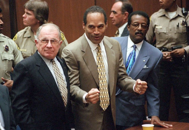 ARCHIVO - O.J. Simpson, flanqueado por los abogados defensores F. Lee Bailey, a la izquierda, y Johnnie L. Cochran Jr., reacciona tras ser declarado inocente de la muerte de su exesposa Nicole Brown Simpson y su amigo Ron Goldman en Los Ángeles, el 3 de octubre de 1995. (Myung J. Chun/Los Angeles Daily News via AP, Pool, archivo)