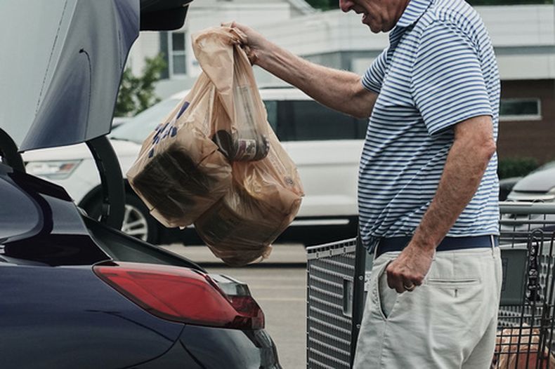 ARCHIVO - Una persona mete a su vehículo bolsas de plástico con comestibles y otros artículos, el 18 de mayo de 2026, en el estacionamiento de un supermercado de Cincinnati. (Foto AP/Joshua A. Bickel, archivo)