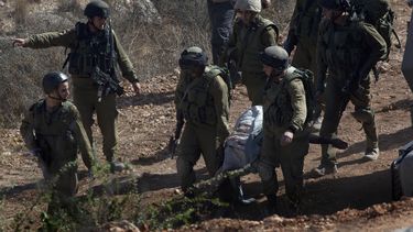 americateve | Soldados israel&iacute;es cargan el cad&aacute;ver de Mohamed Aatzi, extremista palestino de la Yihad Isl&aacute;mica, hacia un veh&iacute;culo del ej&eacute;rcito cerca del poblado de Bilin, a poca distancia de la ciudad cisjordana de Ramal&aacute;, el m