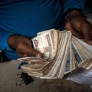 ARCHIVO - Un trabajador muestra un fajo de pesos cubanos el 11 de diciembre de 2020, en La Habana, Cuba. (AP Foto/Ramón Espinosa, Archivo)