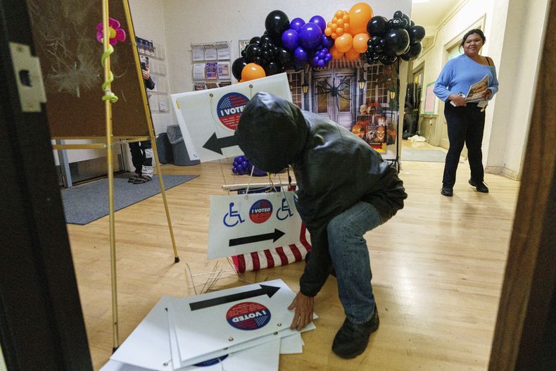 Trabajadores electorales retiran los carteles electorales mientras cierran el centro de votación y entrega de papeletas en el Echo Park Recreation Center el martes 5 de noviembre de 2024, en Los Ángeles. (AP Foto/Damian Dovarganes)
