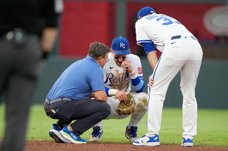 El campocorto de los Royals de Kansas City, Bobby Witt Jr., habla con el mánager Matt Quatraro (derecha) y el entrenador Kyle Turner (izquierda) tras lesionarse mientras fildeaba un sencillo de Jordan Walker, de los Cardenales de San Luis, durante la cuarta entrada de un partido de béisbol el jueves 18 de junio de 2026, en Kansas City, Misuri. (Foto AP/Charlie Riedel)
