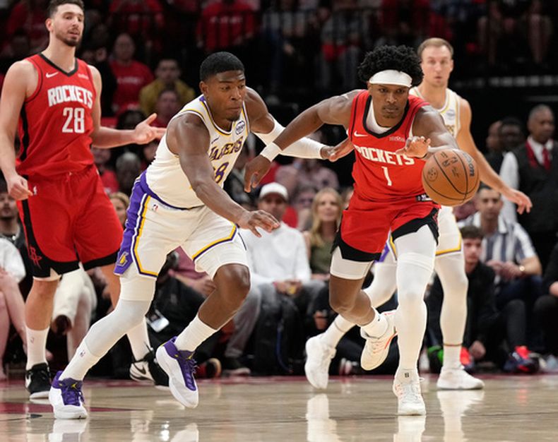 Amen Thompson (1), de los Rockets de Houston, busca alcanzar el balón frente a Rui Hachimura, izquierda, de los Lakers de Los Ángeles, durante la primera mitad del cuarto juego de la serie de primera ronda de los playoffs del baloncesto de la NBA, el domingo 26 de abril de 2026, en Houston. (AP Foto/Karen Warren)