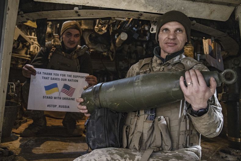 Soldados de la 5ta brigada de Ucrania muestran un cartel de agradecimiento a Estados Unidos por su apoyo durante un flashmob en el frente, cerca de Toretsk, en la región ucraniana de Donetsk, el 11 de marzo de 2025. (AP Foto/Roman Chop)