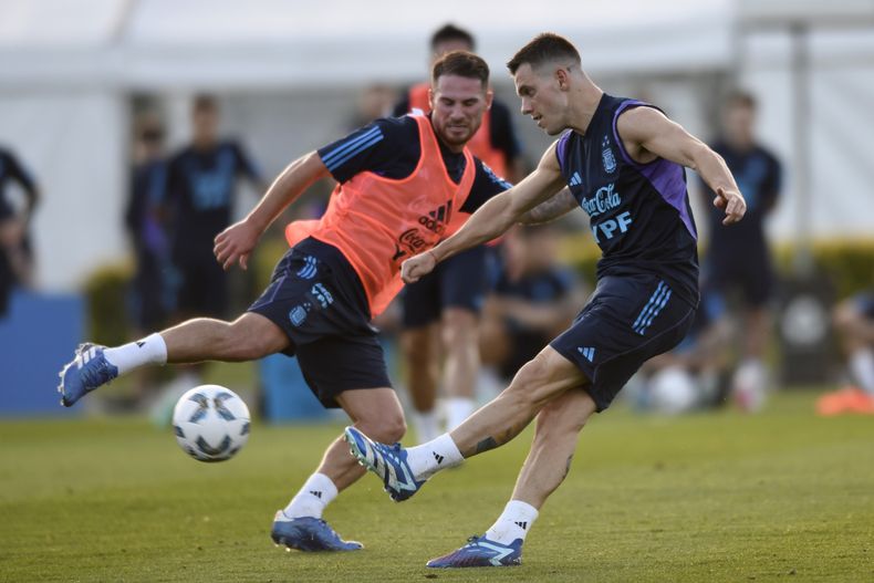 El argentino Giovani pelea por el balón con su compañero Alexis Mac Allister durante un partido en el entrenamiento de la selección antes del encuentro de la eliminatoria a la Copa Mundial 2026 el martes 14 de noviembre del 2023. (AP Foto/Gustavo Garello)