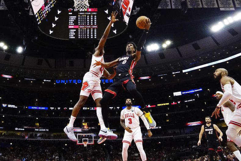 El base de los Bulls de Chicago Ayo Dosunmu defiende al base del Heat de Miami Josh Richardson quien salta con el balón para anotar en el encuentro del lunes 20 de noviembre del 2023. (AP Foto/David Banks)
