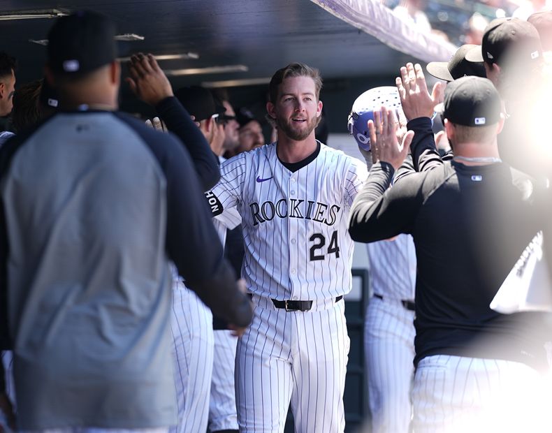 Ryan McMahon de los Rockies de Colorado es felicitado luego de impactar un jonrón de dos carreras ante el abridor venezolano de los Filis de Filadelfia, Ranger Suárez, en la primera entrada del juego de béisbol, el domingo 26 de mayo de 2024, en Denver. (AP Foto/David Zalubowski)