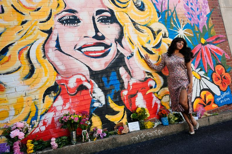 Sunny Holiday posa para una foto cerca de un mural de Dolly Parton, el 25 de agosto de 2026, en Nashville, Tennessee. (AP Foto/George Walker IV)