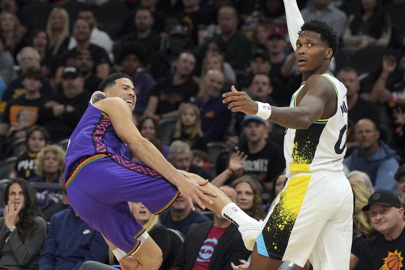 El base de los Suns de Phoenix Devin Booker reacciona a una falta del base de los Pacers de Indiana Bennedict Mathurin en el encuentro del jueves 19 de diciembre del 2024. (AP Foto/Rick Scuteri)