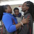 Valerie Laveus saluda a su hermano Reginald Malherbe Daniel y a su sobrino Tristan-Ryan Malherbe Daniel a la llegada de ellos por primera vez a Estados Unidos desde Haití, en el Aeropuerto Internacional Fort Lauderdale-Hollywood el miércoles 9 de agosto de 2023, en Fort Lauderdale, Florida. (AP Foto/Jim Rassol)